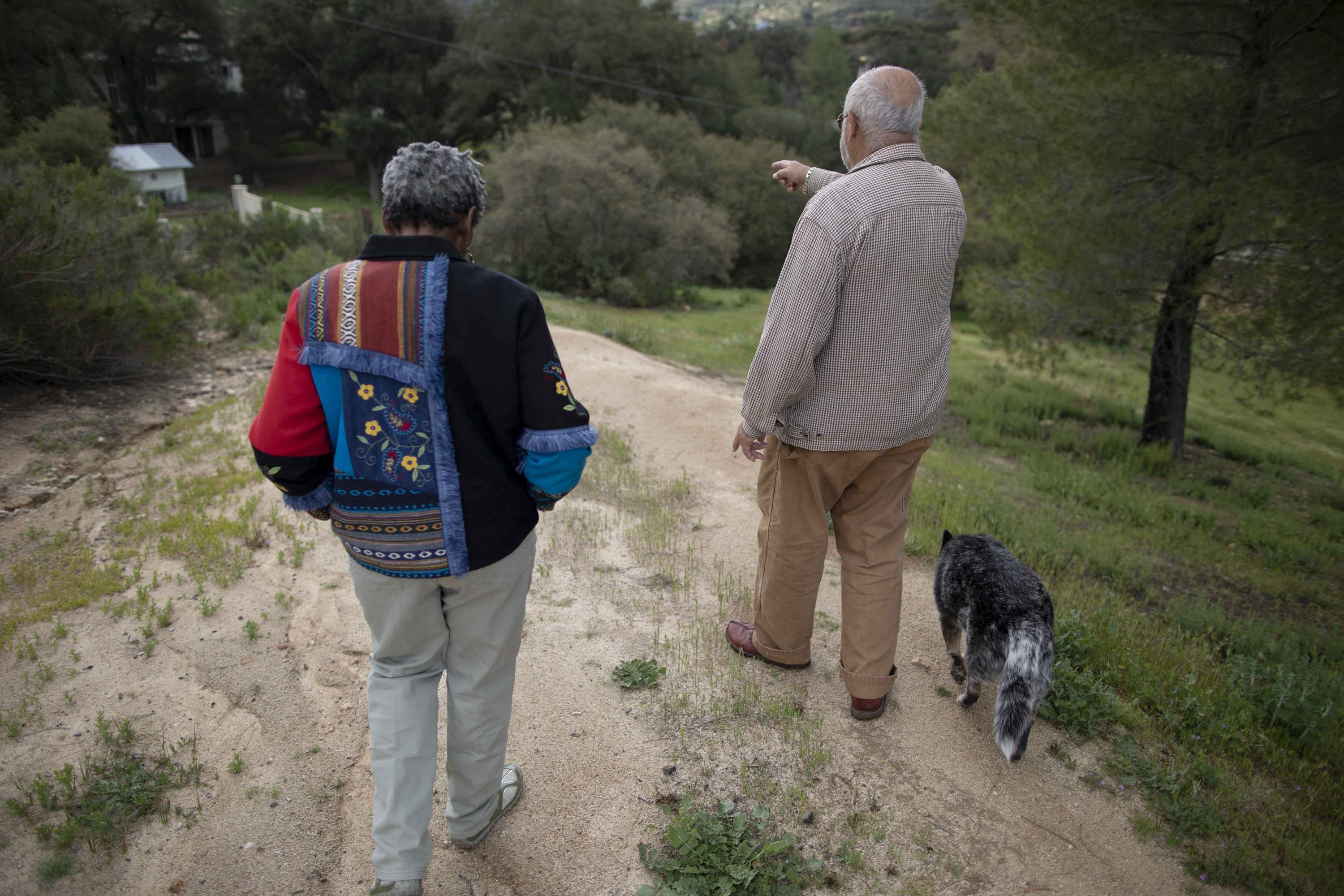 Carlos Luis Ituarte and his wife, Gerda Govine Ituarte, walk with their dog, Tres Colores, on their 4 ½ acre property in rural Jamul.