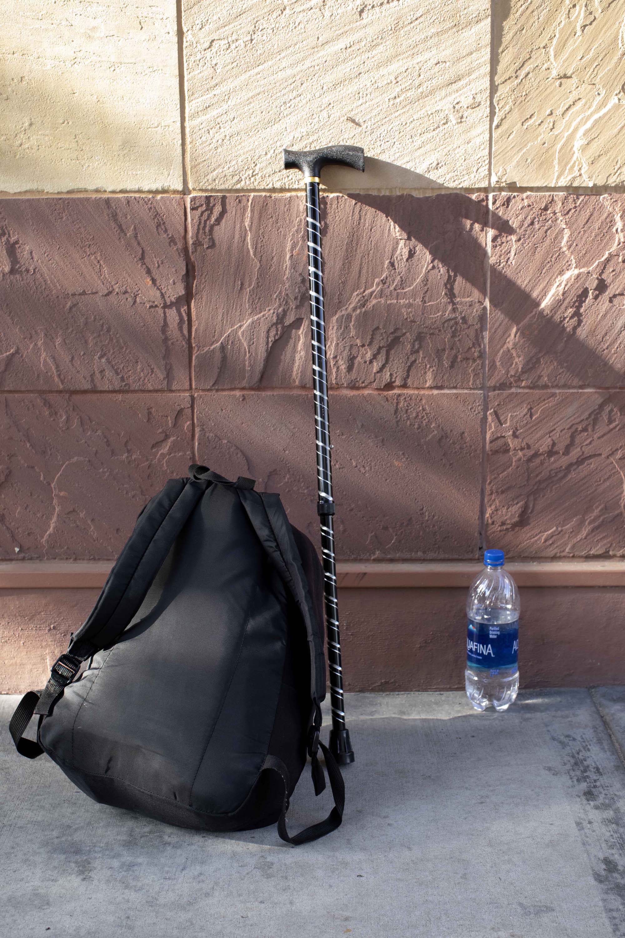 Carl Russell’s cane and backpack rest against the wall of San Diego’s Gary and Mary West Senior Well Center. The cane is his only defense against attack, he says.